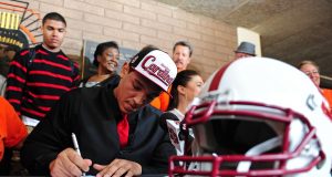 Football Scholarships A group of people sitting at a table with a helmet on