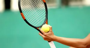 Getting Ready for the New Tennis Season A person holding a racket and a ball
