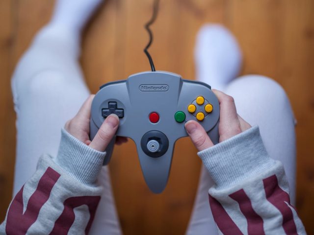 A hand holding a game remote control